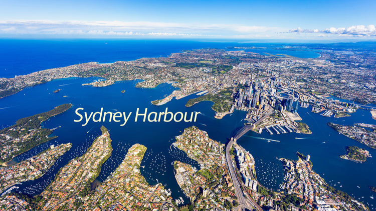 A high altitude aerial photograph showing Sydney Harbour. Taken from above North Sydney, looking south across the Harbour to Sydney CBD and the Eastern Suburbs.